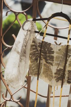 two pieces of cloth hanging from a metal fence