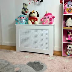 several stuffed animals sitting on top of a white cabinet