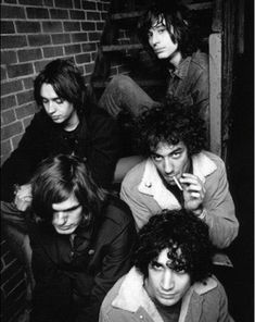 the ramon band posing for a black and white photo in front of a brick wall