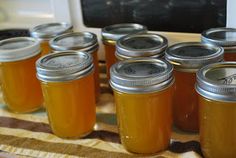 several jars of honey sit on a table in front of an open microwave oven door