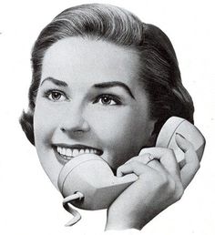 a black and white photo of a woman talking on the phone