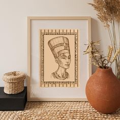 an egyptian woman's head is shown in a frame next to a potted plant