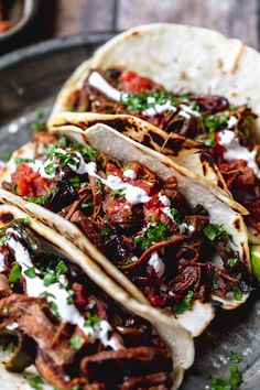 three shredded beef tacos on a plate