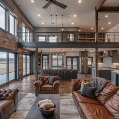 a living room filled with lots of furniture next to a kitchen and an open floor plan