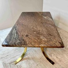 a marble top coffee table with brass legs