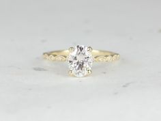 a yellow gold engagement ring with an oval cut diamond