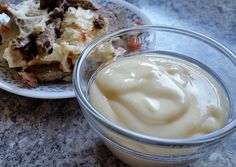 a plate with food on it next to a glass bowl filled with cream cheese sauce