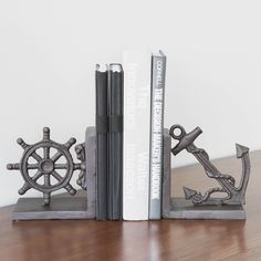 two metal bookends with books on top of them and one is holding an anchor