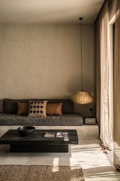 a living room with a couch, coffee table and lamp on the wall in front of it