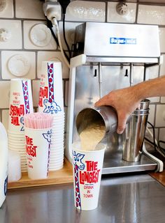 a person pours some milk into cups