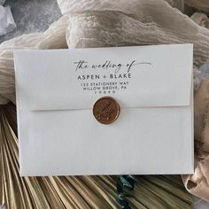 an envelope with a wax stamp on it sitting next to some paper and other items