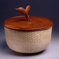 a basket with a lid and wooden handle