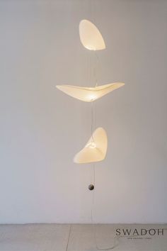 three lamps suspended in the air above a floor