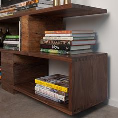 the bookshelf is made out of wood and has several different types of books on it