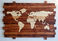 a wooden pallet with a world map on it's side, hanging from the wall