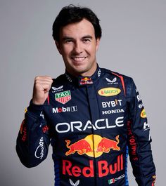 a man in a red bull racing suit holding his jacket up to the camera with both hands