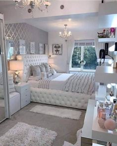 a bedroom with white furniture and chandelier