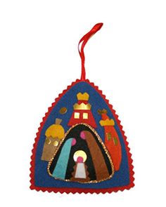 a christmas ornament hanging from a red ribbon on a white background with an image of the nativity scene