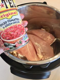 someone is holding a can of canned tuna in an instant pot