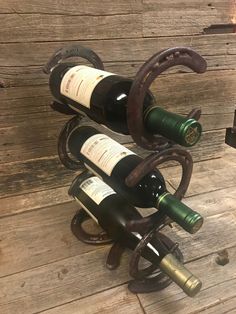 three wine bottles are stacked on top of each other in the shape of horseshoes