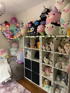 a room filled with lots of stuffed animals next to a white shelf full of toys