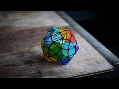 a close up of a colorful object on a wooden surface with dark background and no one around it