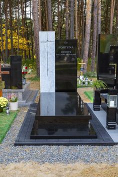 the memorial is surrounded by many black and white tombstones in front of some trees