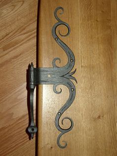 an ornate iron handle on a wooden door