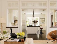 a living room filled with lots of furniture and flowers in vases on the coffee table