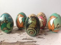 five painted eggs sitting on top of a wooden table