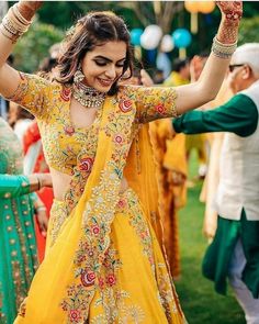 a woman in yellow dress dancing with other people