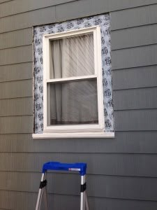 a ladder is next to a window with curtains on it