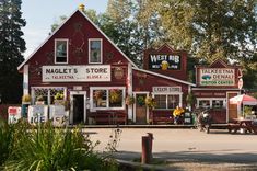 a red building with many signs and people sitting at tables in front of the store