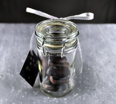 a glass jar filled with lots of coins and a tag on the top of it