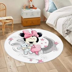 a minnie mouse rug is on the floor next to a bed