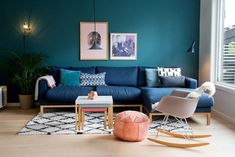 a living room filled with furniture and a blue couch in front of a large window