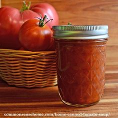 tomatoes in a basket next to a jar of tomato sauce