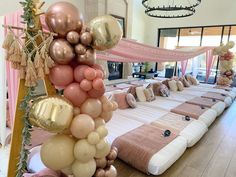 a large bed with lots of balloons on top of it in the middle of a room