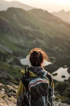 a person standing on top of a mountain with a backpack in their hand and the words written