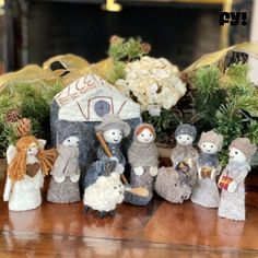 a group of figurines sitting on top of a wooden table next to flowers