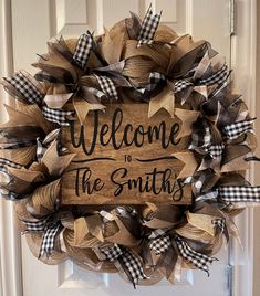 a welcome to the smiths wreath hanging on a door with burlocks and ribbon