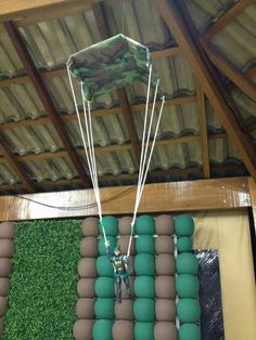 a man is parasailing in the air over some balls and grass on display