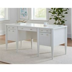 a white desk with two drawers and a plant in the corner on top of it