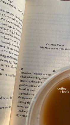 an open book sitting on top of a table next to a cup of coffee in front of it