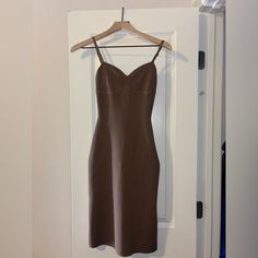 a brown dress hanging on a white door