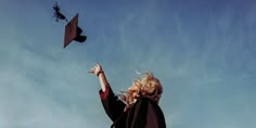 a woman flying a graduation cap in the air