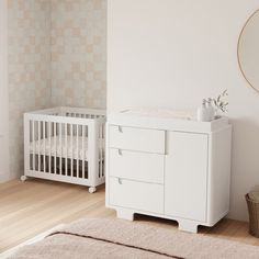 a white crib next to a wall with a mirror and rug on the floor