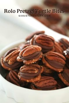 a bowl filled with chocolate covered pretzels on top of a table