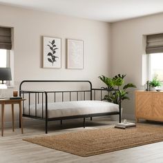 a bed room with a neatly made bed next to a table and two plants on the wall