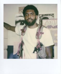 a man with suspenders and a white t - shirt is posing for a photo